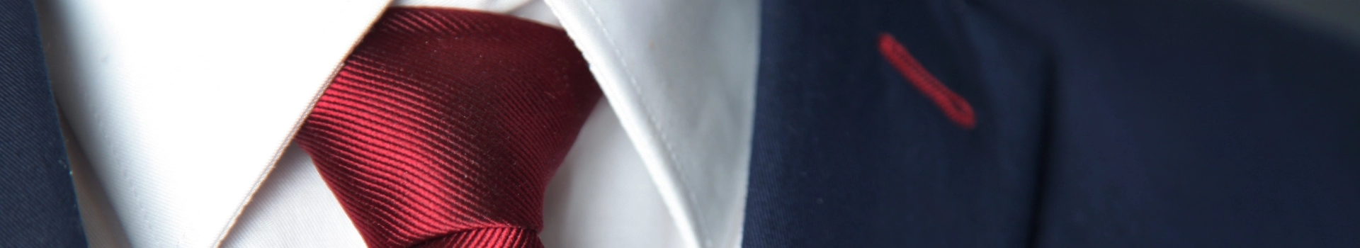 Czerwony krawat z białą koszulą i granatową marynarką